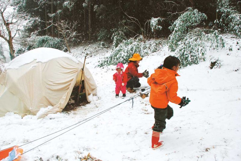 帳篷外一片白雪。次女．結和媽媽．深雪在堆雪人，長女．朱里熱衷玩雪撬。（晨星出版提供）
