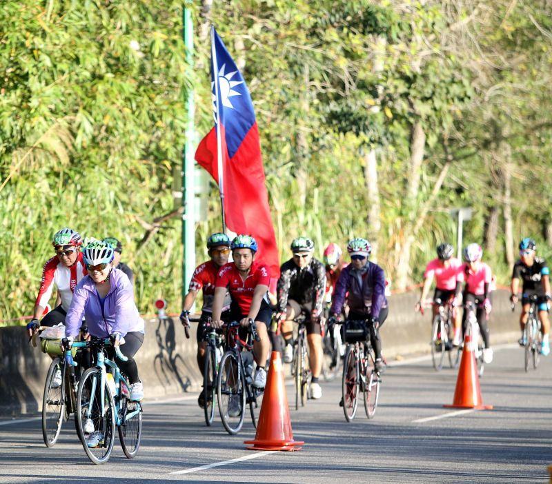 日月潭單車嘉年華會，有車友帶著國旗騎車。中華民國 自行車騎士協會／提供。