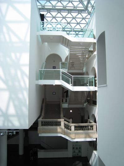 樓梯掛在一隅，光線則灑入中庭，映照在白牆上，多層次的空間效果創造出景深。(攝影/林芳怡)