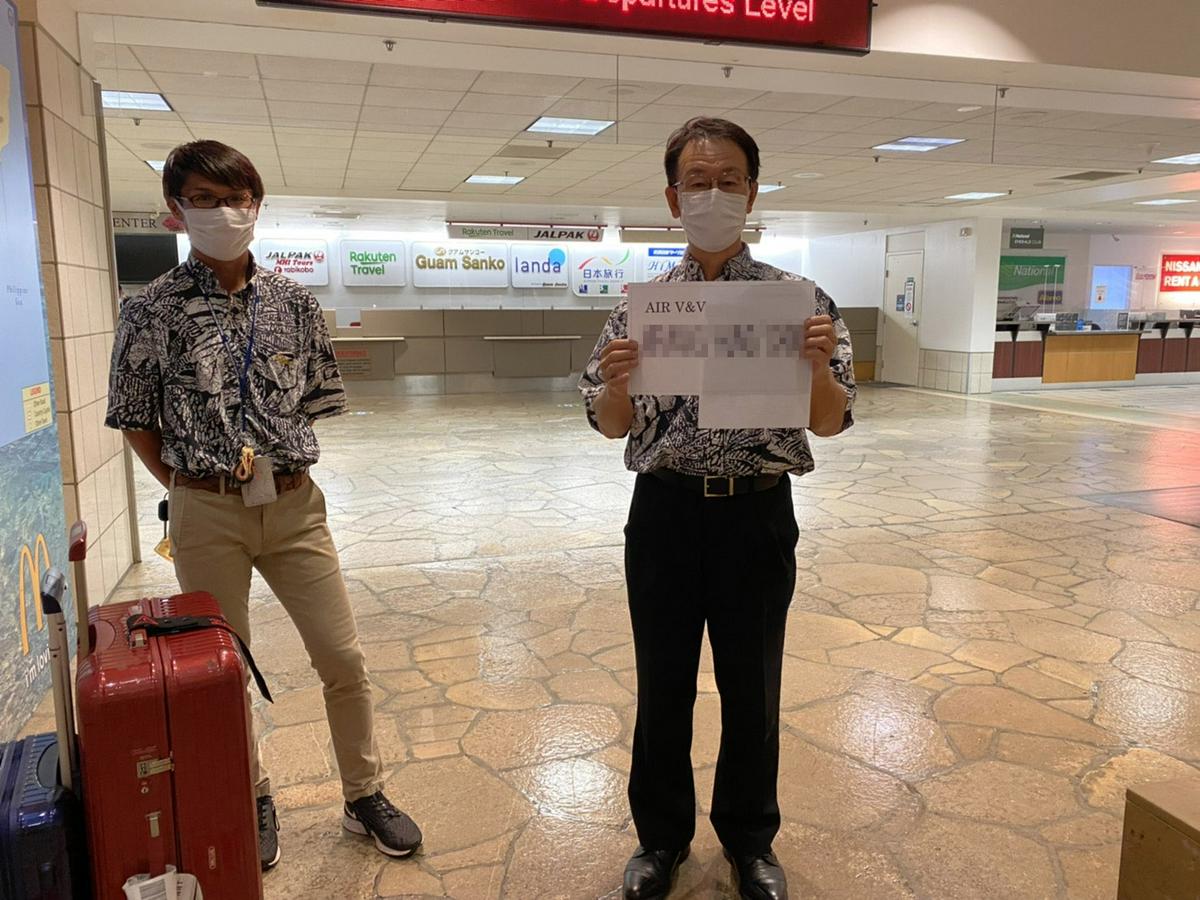 關島機場有飯店人員，舉了Air V&V的牌子接機