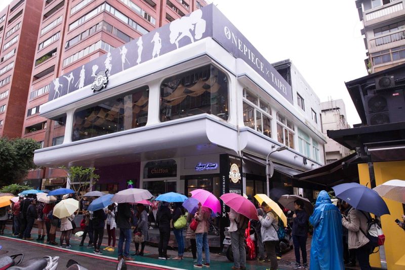 熱血粉絲不畏雨天撐著傘排隊搶先入座。(《台灣航海王》餐廳提供)
