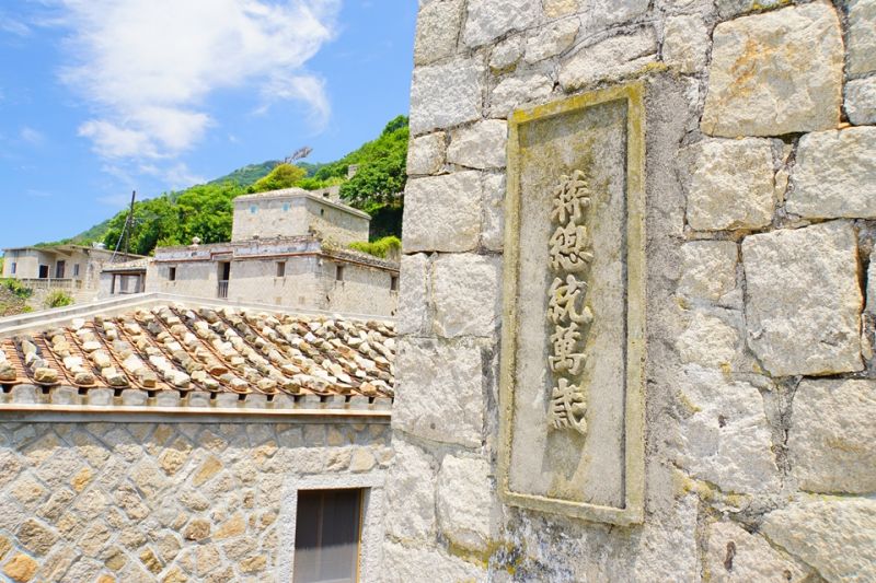 芹壁村在各個轉角的石頭牆上留下不少「精神標語」, 提醒當時居民隨時警戒的重要。;圖片提供/馬可孛羅