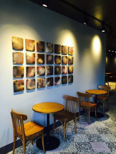 鶯歌門市其中有與當地陶藝家合作設計，為星巴克燒製具有咖啡圖騰的窯燒陶片，以拼貼藝術創造出藝術牆面。(統一星巴克提供)