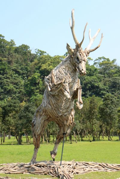 運用漂流木堆砌成的台灣水鹿，英姿煥發，在綠地與藍天間跳躍。(攝影趙相瑀)