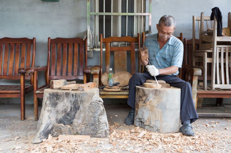 農家阿伯一槌一槌的雕著，費心地做出各式各樣精美的木藝品。