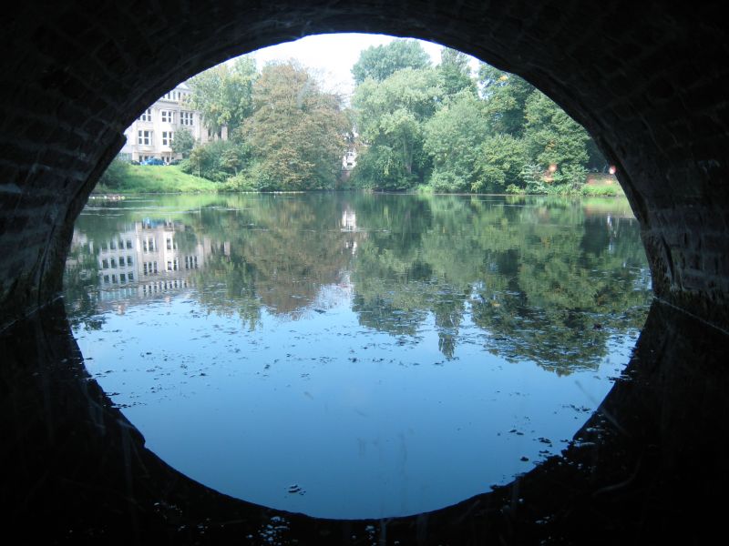 地下室舊有的圓窗與水中倒影，映照週邊公園的美景。(攝影/林芳怡)