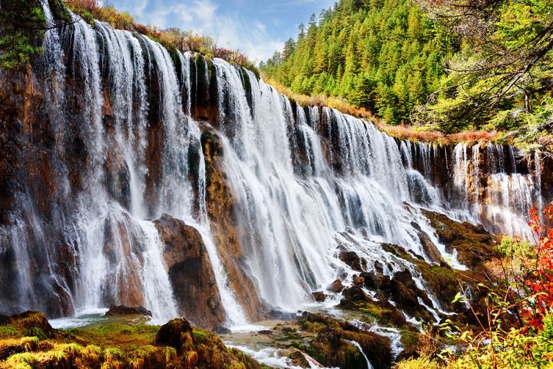 高低落差極大的諾日朗瀑布，為美麗的山巒增添了幾分活力與生氣。（圖片來源：123RF）