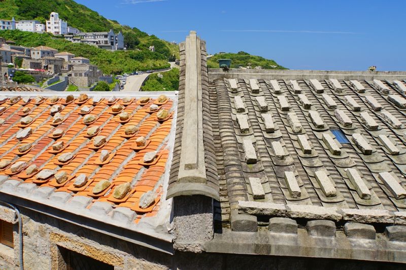 芹壁屋頂上常見規則排列的壓瓦石，避免強風將瓦片吹落，形成馬祖的傳統屋頂上一個有趣的景象。；圖片提供/馬可孛羅